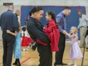 Kirk Hernandez Jr., center, an inmate at Larch Corrections Center, takes a turn around the dance floor during a slow song with his daughter, Eternity, 5, on Saturday during the prison&#039;s father-daughter dance.