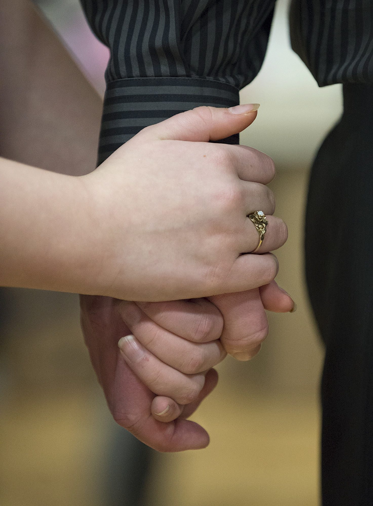 Jonathan Johnson, an inmate at Larch Corrections Center, holds hands with his daughter, Paige, 11, during a break from the dance floor Saturday.