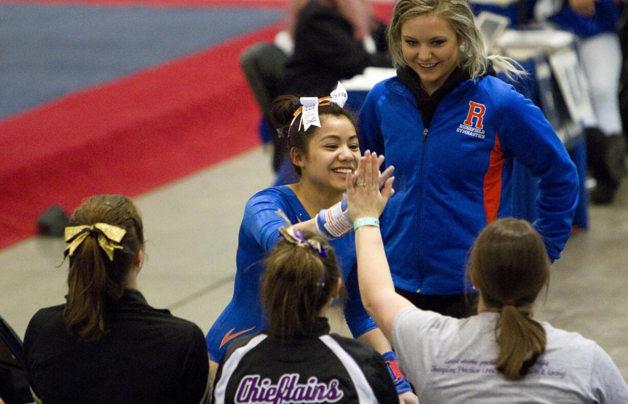 Ridgefield's Kylee Tjensvold receives congratulations after her routiine on the bars during the 1A/2A/3A State Gymnastics Finals Saturday, Feb. 20, 2016. Tjensvold  scored 9.125 in the event and took seventh place.