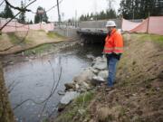 Kevin Workman of the Washington State Department of Transportation looks over a recently constructed culvert at Mill Creek along state Highway 502 near Battle Ground on Monday. Modern culverts are designed and installed to mesh with all life phases of migratory fish.