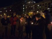 Adam Kravitz, right, founder of Outsiders Inn, leads a late December candlelight vigil as members of the community remember homeless people who died in the past year.