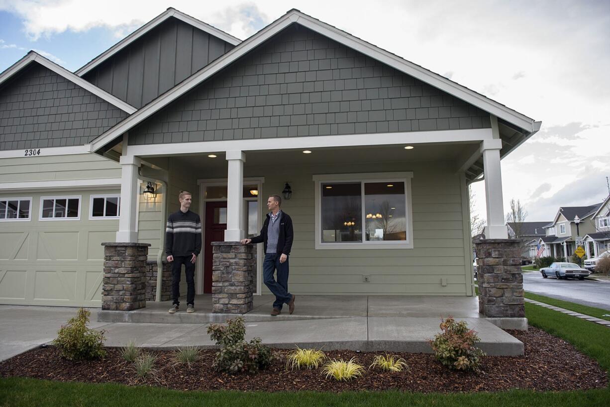 Andrew Olin, 22, of Olin Homes, left, talks with his father, Ivan Olin, 46, as they stand near the front of a model home in Battle Ground that is wheelchair-accessible and designed for aging in place.