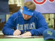 Mountain View&#039;s Chris Mitchell, a football player, signs a contract to play football for the Air Force Academy, during a ceremony at his school in Vancouver Wednesday February 3, 2016.