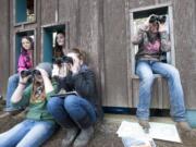 La Center Middle School sixth-graders Adriana Barbier, from left, Natalie Schlecht and Mazy Kendall use binoculars to do some bird-watching Thursday during a field trip to the La Center Bottoms.