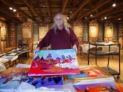 Roben White holds the painting &quot;Cowards&quot; by Brent Learned while unpacking an exhibit documenting the 1864 Sand Creek, Colo., massacre for the &quot;One November Morning&quot; exhibit at the Clark County Historical Museum. White, a museum volunteer, is a descendant of massacre survivors.