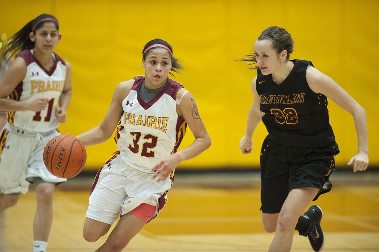 Prairie&#039;s Cherita Daugherty (32) takes on Enumclaw defender Jessica Cerne (32) as teammate Kris Rocci (11) trails on the play in the first quarter Thursday night, Feb. 11, 2016 at Prairie High School.