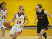 Prairie&#039;s Cherita Daugherty (32) takes on Enumclaw defender Jessica Cerne (32) as teammate Kris Rocci (11) trails on the play in the first quarter Thursday night, Feb. 11, 2016 at Prairie High School.