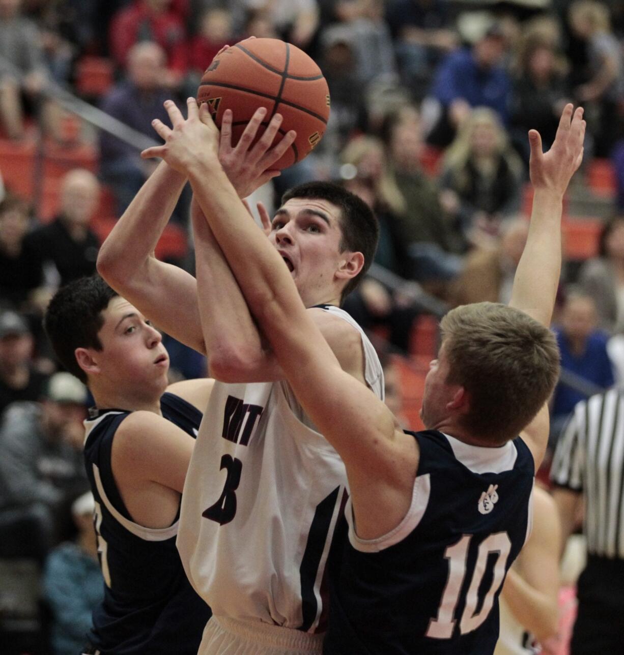 King's Way Christian's Kienan Walter, center, shoots against Cascade Christian defenders during playoff game at Battle Ground High School.