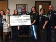 Lynn Miller, Bridge the Gap board chair, second from left, is presented a check from Seahawks Booster Club members, from left, Wendy Rawlings, Miller, Deanna Bevans, Larry Bevans, Julie Gutenberger, Brandi Bazurto and Ryan Gutenberger.