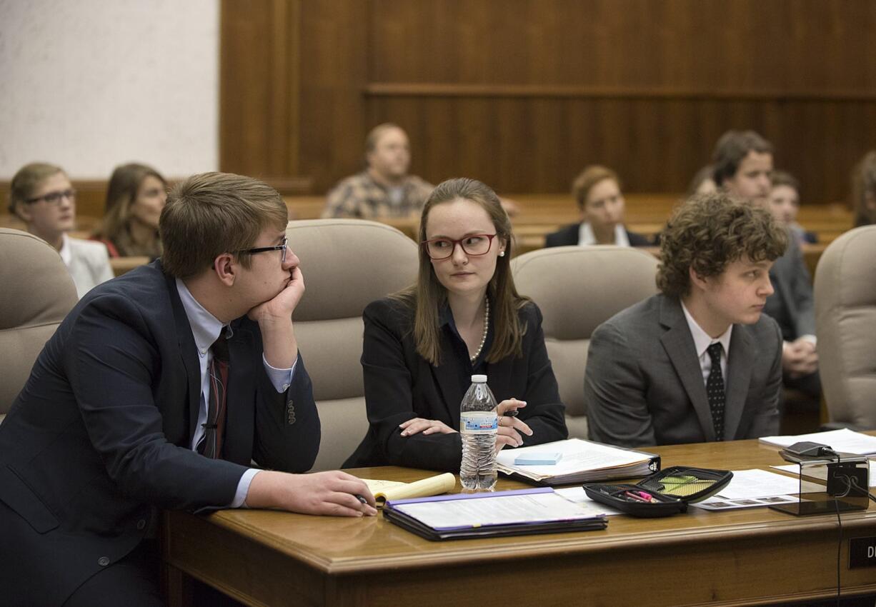 Camas High School students Bracy Ratcliff, 17, from left, Baylee Allen, 18, and Alex McOmie, 17, consult at the defense counsel table during Clark County&#039;s two-day district mock trial tournament Thursday at the Clark County Courthouse.