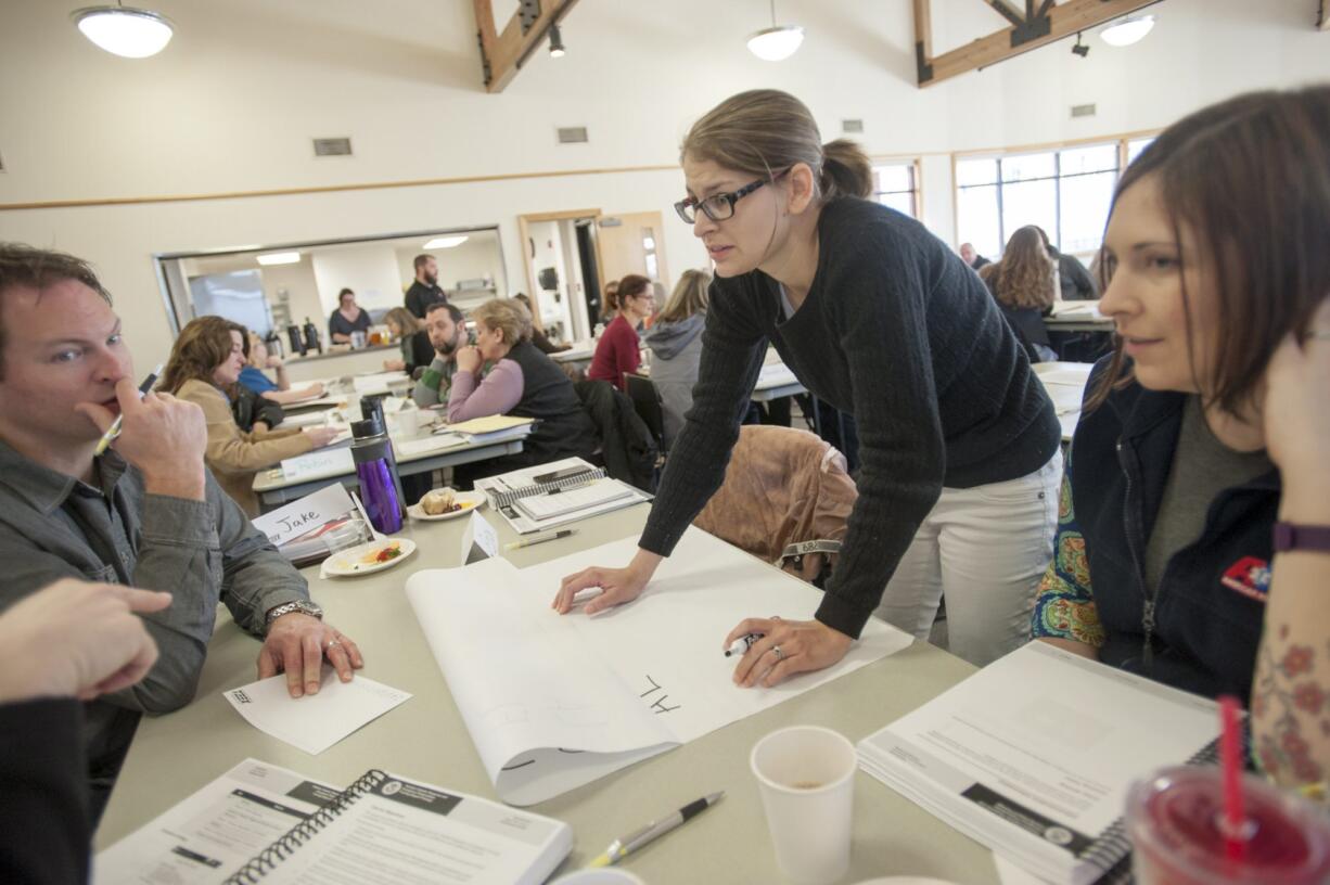 Jake Shores, with American Medical Response, left to right, Erica Higgins, with Innovative Services Northwest, and Kim Earls, with American Medical Response, brainstorm ideas during pediatric disaster preparedness training Tuesday at the Water Resources Education Center in Vancouver.  The two-day training focused on how community organizations can meet the unique physical, mental and emotional needs of children in disasters.