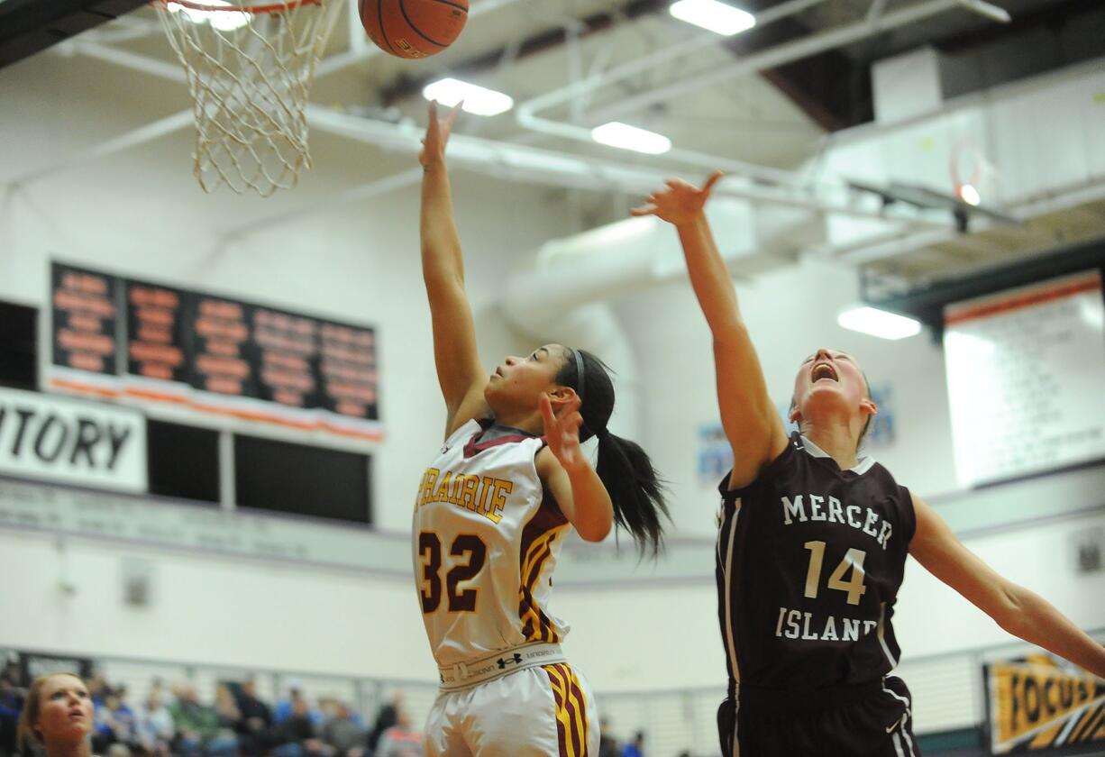 Prairie's Cherita Daugherty (32) surges past Mercer Island's Jessica Blakeslee (14) for two of her 15 points in the Falcons' 57-41 victory in the 3A state regional playoffs at Battle Ground High School.