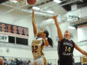 Prairie's Cherita Daugherty (32) surges past Mercer Island's Jessica Blakeslee (14) for two of her 15 points in the Falcons' 57-41 victory in the 3A state regional playoffs at Battle Ground High School.