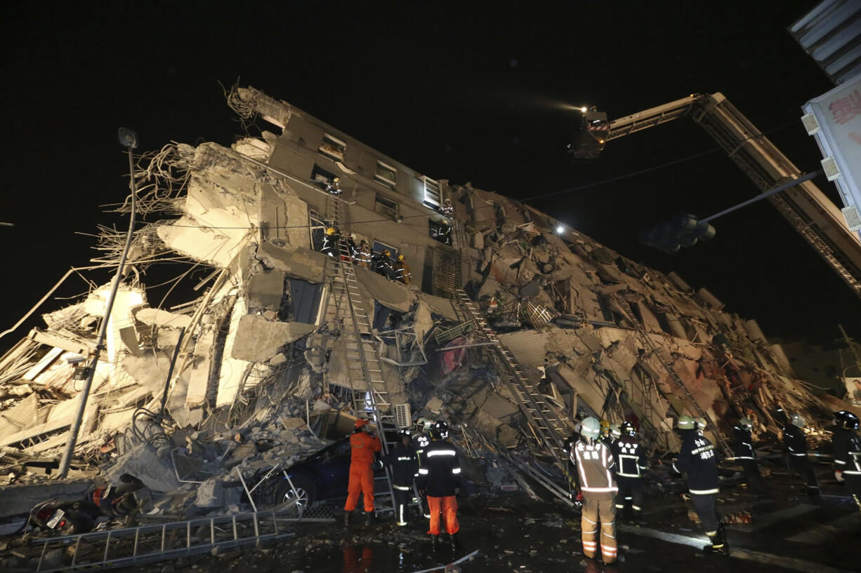 Rescue workers search a toppled building after a 6.4-magnitude earthquake early today in Tainan, Taiwan.