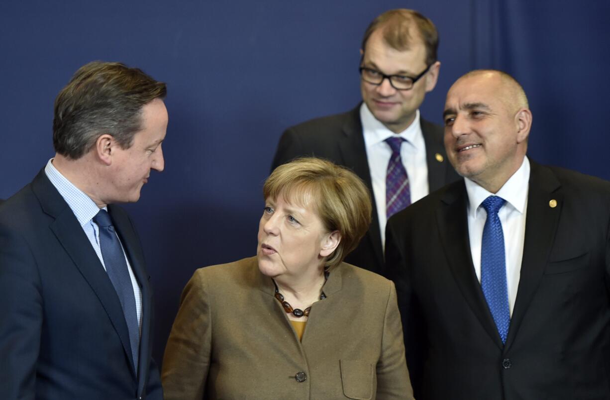 German Chancellor Angela Merkel, center, speaks with British Prime Minister David Cameron, left, during a group photo at an EU summit in Brussels on Thursday. European Union leaders are holding a summit in Brussels on Thursday and Friday to hammer out a deal designed to keep Britain in the 28-nation bloc. At right is Bulgarian Prime Minister Boyko Borisov and second right is Finnish Prime Minister Juha Sipila.