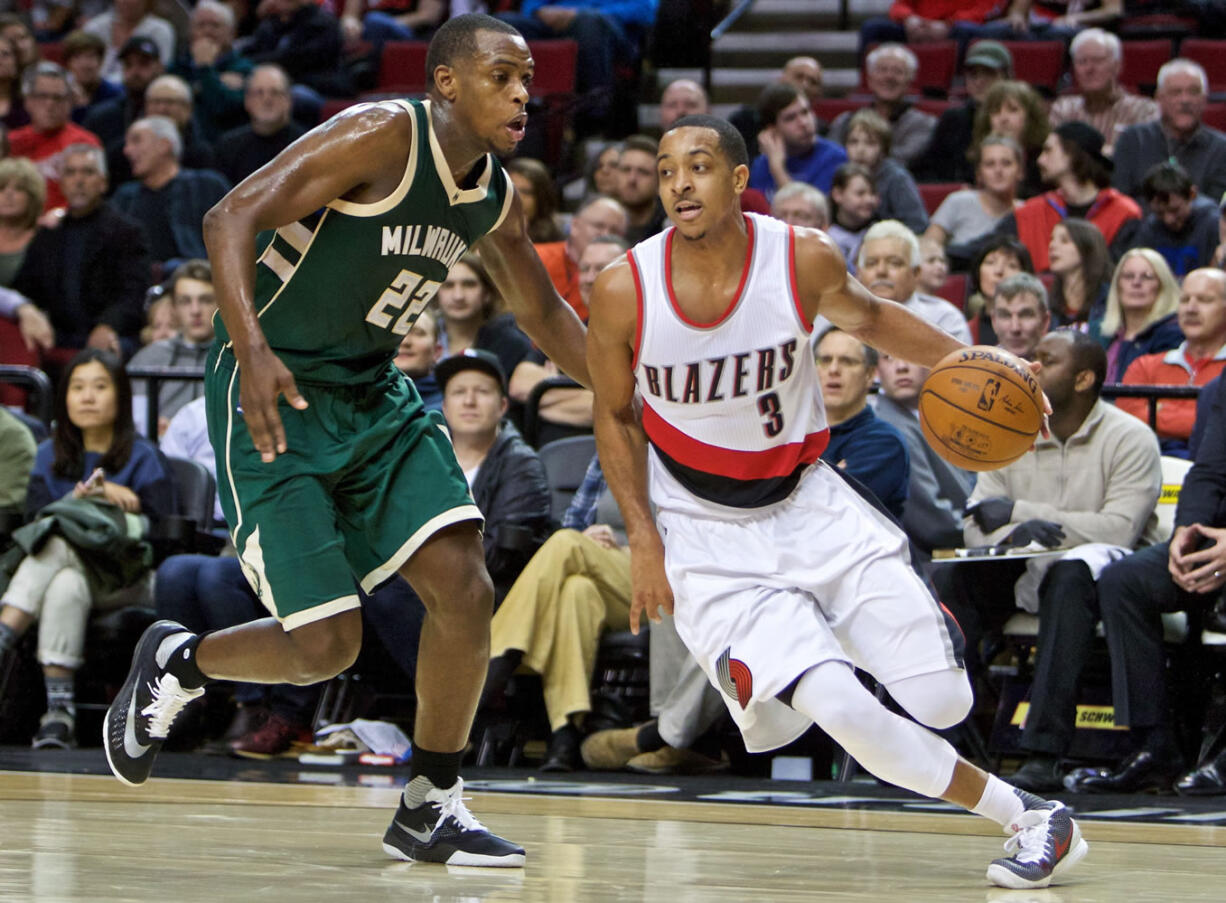 Portland Trail Blazers guard C.J. McCollum, right, dribbles past Milwaukee Bucks guard Khris Middleton during the second half of an NBA basketball game in Portland, Ore., Tuesday, Feb. 2, 2016. The Trail Blazers won 107-95.