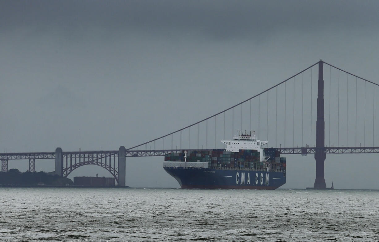 A container ship passes the Golden Gate bridge under cloudy skies Wednesday in San Francisco Bay. After three days of record-breaking heat, a cold front from Oregon brought high winds and rain to Northern California, Wednesday with strong gusts in the San Francisco Bay Area.