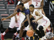 California's Roger Moute a Bidias, left, and Washington State's Que Johnson go after a loose ball during the first half of an NCAA college basketball game, Sunday, Feb. 21, 2016, in Pullman, Wash.