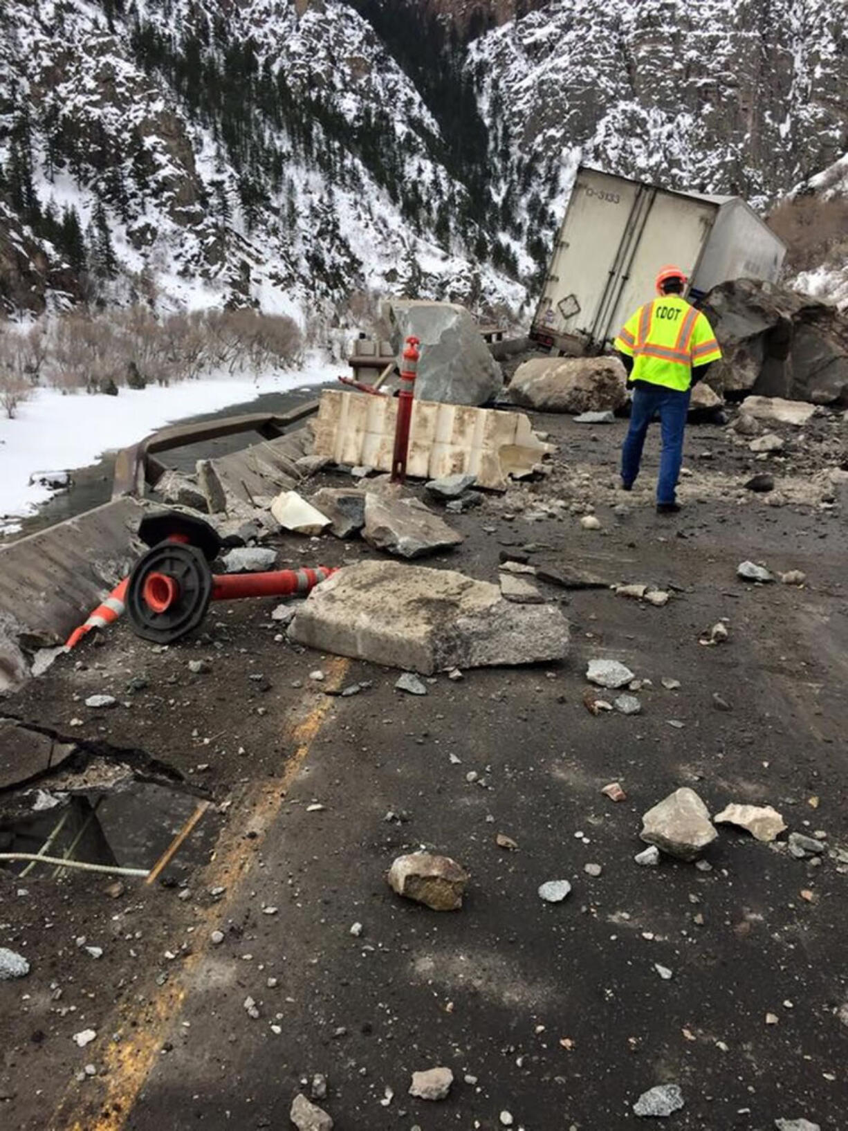 A Colorado Department of Transportation worker examines debris Tuesday from a rock slide on Interstate 70 in Glenwood Canyon in Colorado. A rock the size of a small car damaged a tractor-trailer in the Monday incident, but no one was injured, state officials said. The interstate was closed in both directions while the canyon walls were inspected and the damage repaired.