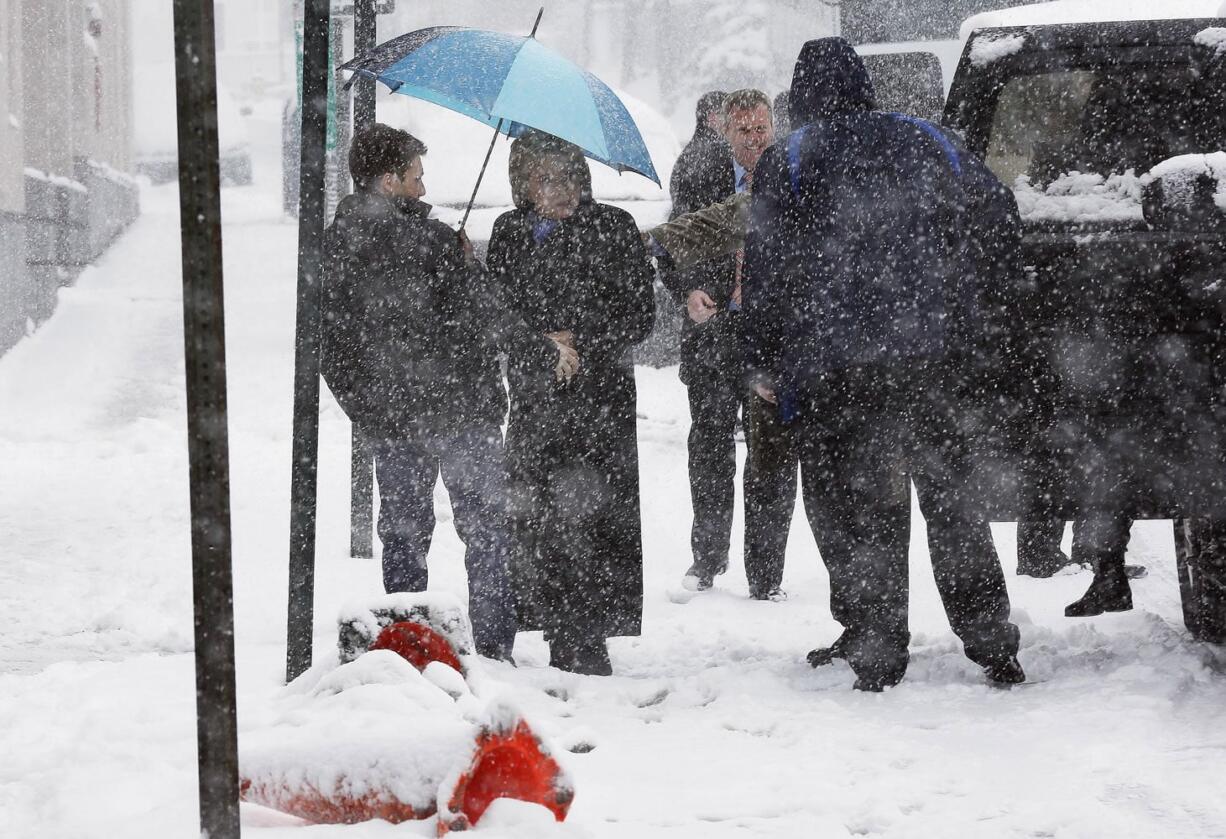 Democratic presidential candidate Hillary Clinton arrives in the falling snow for a campaign stop, Friday, Feb. 5, 2016, in Manchester, N.H.