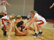 Madison Freemon, left, and Meghan Finley of Camas battle for the ball with Union's Kili Anderson during a 4A District 4 Girls Basketball Tournament game Thursday at Camas (Micah Rice/The Columbian).