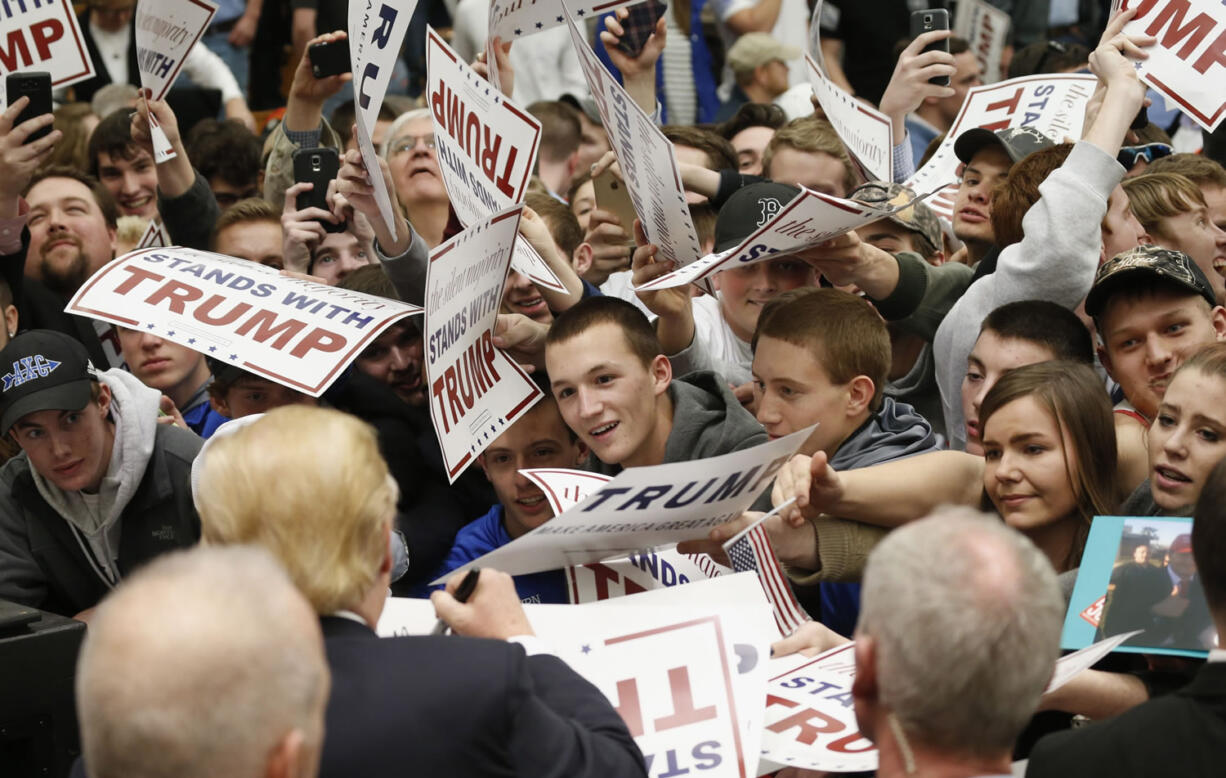 Supporters of Republican presidential candidate, Donald Trump strive to get an autograph during a rally at Radford University in Radford, Va., Monday.