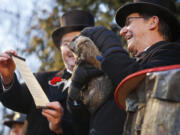 Co-handler Ron Ploucha, right, holds Punxsutawney Phil as Jeff Lundy, vice president of the Inner Circle of the Punxsutawney Groundhog Club, holds the scroll Tuesday during the annual celebration of Groundhog Day on Gobbler&#039;s Knob in Punxsutawney, Pa.