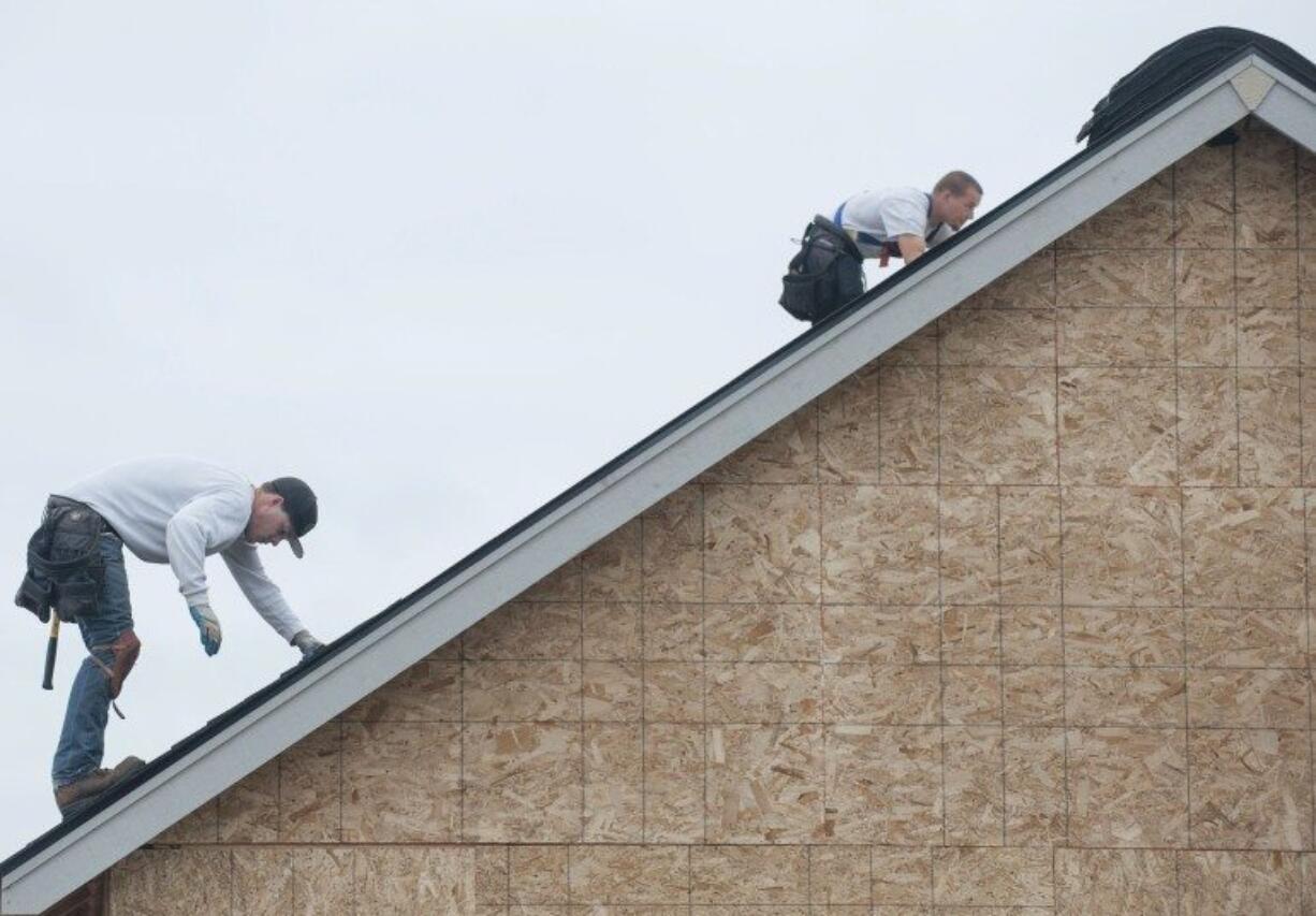 Construction workers build homes in spring 2015 to accommodate an expanding population at a development off Lakeshore Avenue in Vancouver.