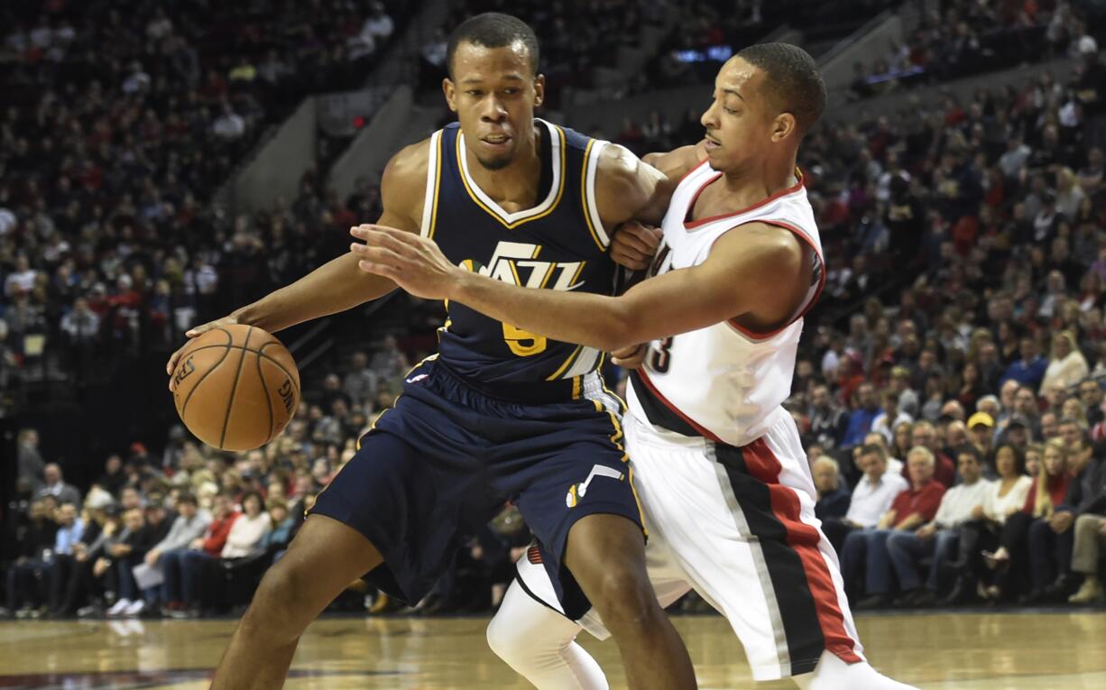 Utah Jazz guard Rodney Hood (5) tries to get around Portland Trail Blazers guard C.J. McCollum (3) during the first half of an NBA basketball game in Portland, Ore., Sunday, Feb. 21, 2016.