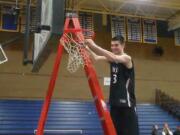 King's Way Christian's Kienan Walter cuts down the net after the Knights' district championship win (Tim Martinez/The Columbian)