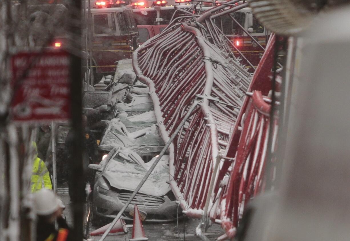 A collapsed crane crushed cars along the street on Friday, Feb. 5, 2016, in New York. The crane landed across an intersection and stretched much of a block in the Tribeca neighborhood, about 10 blocks north of the World Trade Center.