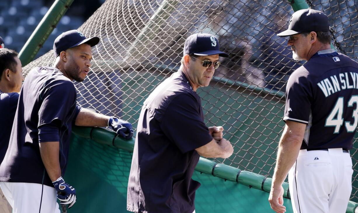 The Seattle Mariners' hitting coach, Edgar Martinez, center, stands with assistant hitting coach Andy Van Slyke (43) and Robinson Cano outside the batting cage in this June 2015 photo. Robinson Cano didn't spend much time dwelling on the searing comments a former assistant coach made about him. He was home in the Dominican Republic, recovering from surgery to repair a sports hernia that he played through for the final two months of last season. The Seattle Mariners' six-time All-Star second baseman addressed former assistant hitting coach Andy Van Slyke's offseason criticism of him on Thursday, Feb. 25, 2016, before the first full-squad workout of spring training.