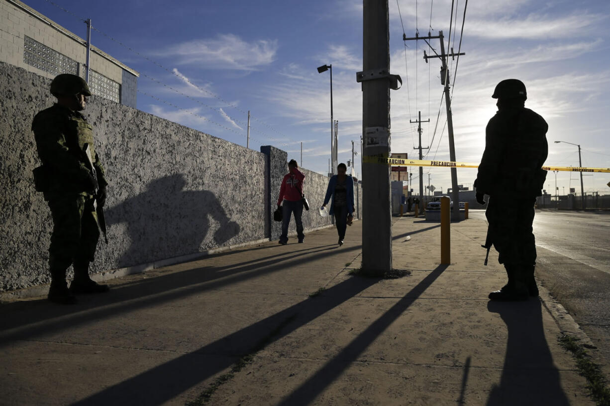 Soldiers stand guard as people arrive to get a glimpse of Pope Francis along the pontiff&#039;s planned route in Cuidad Juarez, Mexico, on Wednesday.