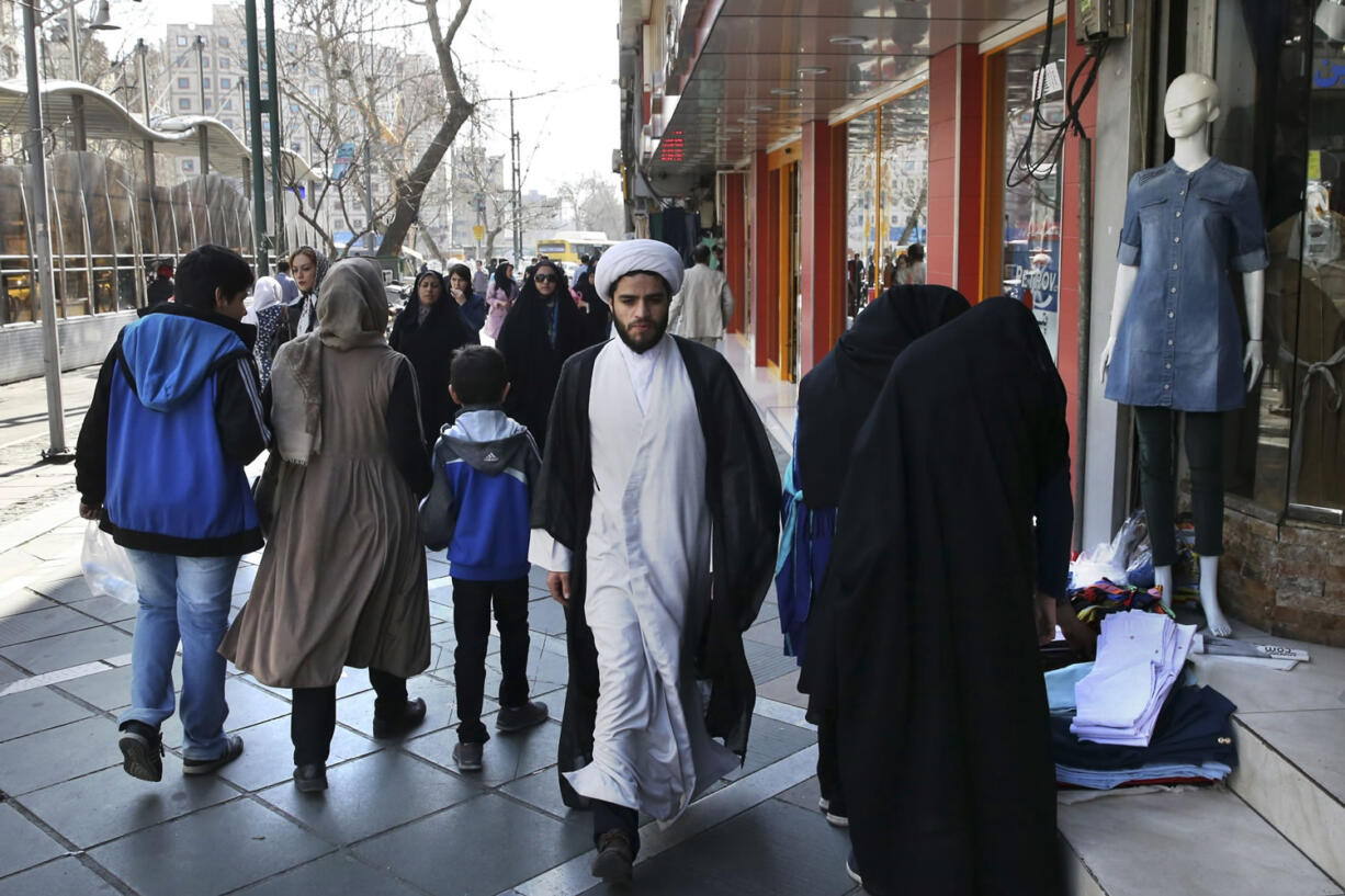 A clergyman walks in central Tehran a day after parliamentary and Experts Assembly elections in Iran, Saturday, Feb. 27, 2016. Preliminary results early Saturday morning showed reformist candidates heading for their best showing in more than a decade in Iranian parliamentary elections, according to local media and election officials counting the ballots. A strong reformist showing would be a boost for moderate President Hassan Rouhani, who championed the newly implemented Iranian nuclear deal with world powers in the face of harsh hard-line opposition.