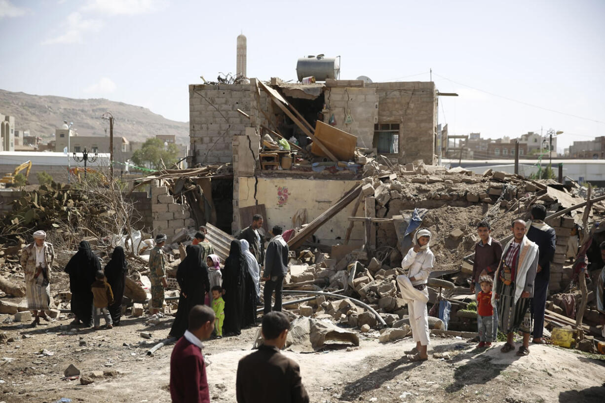 People gather near a house destroyed in a Saudi-led airstrike Thursday in Sanaa, Yemen.