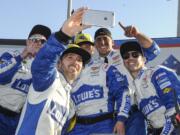 Jimmie Johnson, second from left, takes a selfie with his crew after winning a NASCAR Sprint Cup Series auto race at Atlanta Motor Speedway on Sunday, Feb. 28, 2016, in Hampton, Ga.