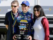 Chase Elliott, center, poses with his parents, former NASCAR driver Bill Elliott, left, and Cindy Elliott, after he qualified for the pole position in the Daytona 500 auto race at Daytona International Speedway, Sunday, Feb. 14, 2016, in Daytona Beach, Fla.