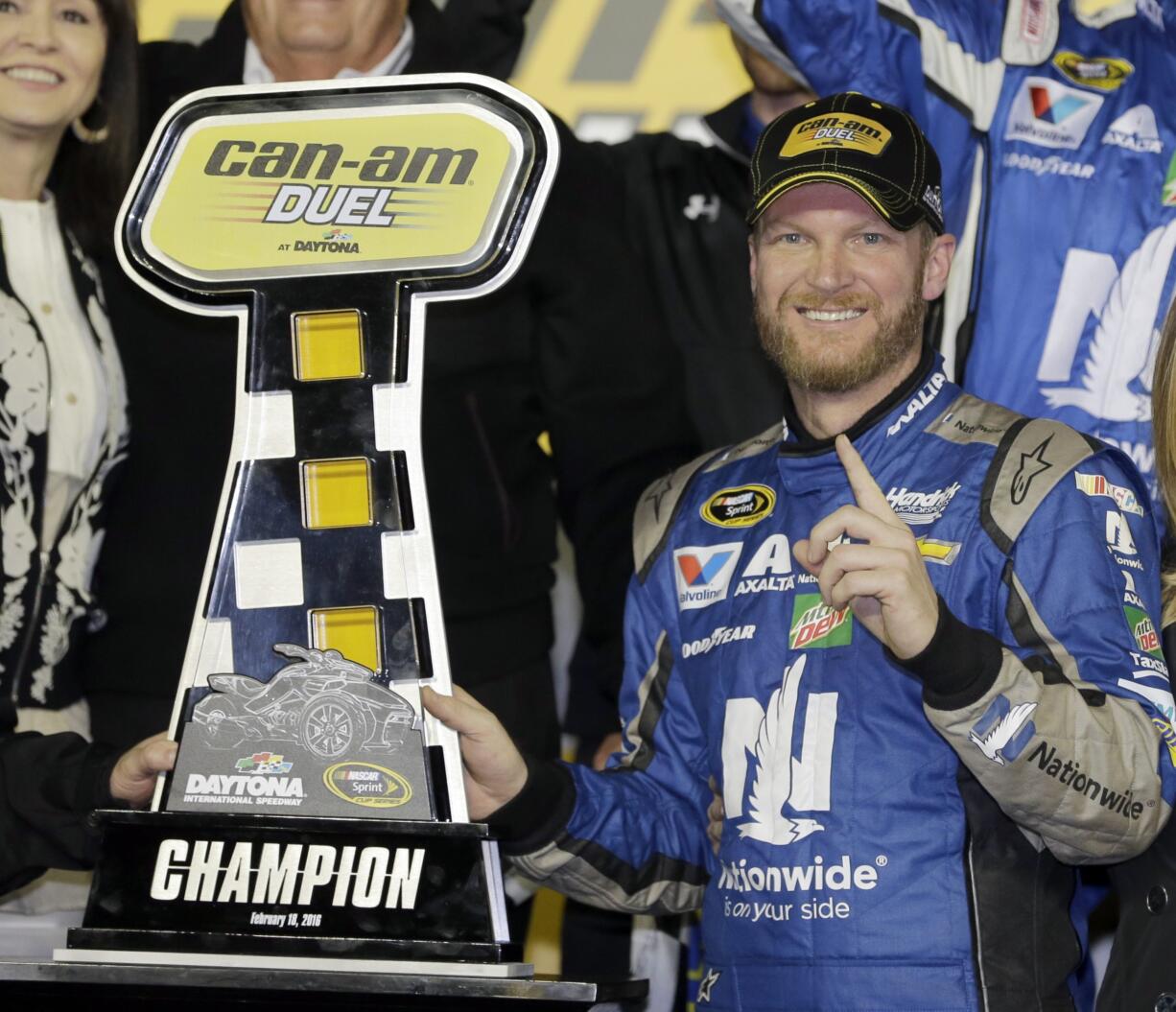 Dale Earnhardt Jr poses with the trophy in Victory Lane after winning the first of two qualifying races for Sunday's NASCAR Daytona 500 Sprint Cup series auto race at Daytona International Speedway in Daytona Beach, Fla., Thursday, Feb. 18, 2016.