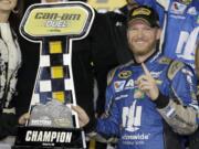 Dale Earnhardt Jr poses with the trophy in Victory Lane after winning the first of two qualifying races for Sunday's NASCAR Daytona 500 Sprint Cup series auto race at Daytona International Speedway in Daytona Beach, Fla., Thursday, Feb. 18, 2016.