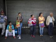 People wait in line Wednesday to buy groceries at government-regulated prices in Caracas, Venezuela. Venezuela&#039;s government earns 95 percent of its export income from oil, and its economy was already unraveling before the plunge in oil prices. Long lines for food and other scarce goods are commonplace.