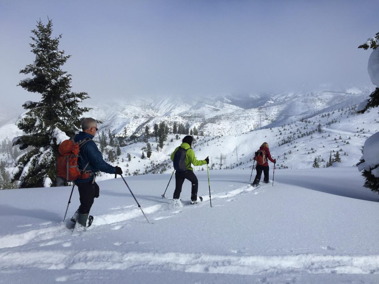 Leo Hennessy, from left, DeEtta Petersen and Bea Purchase snowshoe in late January toward the Banner Ridge yurt in Idaho City, Idaho.