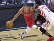 Portland Trail Blazers guard C.J. McCollum, left, dribbles past Houston Rockets guard Patrick Beverley during the second half of an NBA basketball game in Portland, Ore., Thursday, Feb. 25, 2016.