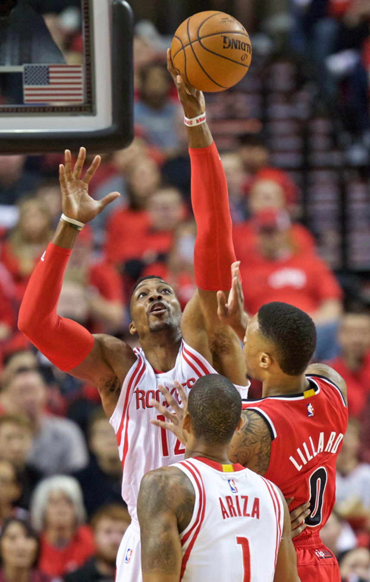 Houston Rockets center Dwight Howard, left, blocks a shot by Portland Trail Blazers guard Damian Lillard, right, during the first half of an NBA basketball game in Portland, Ore., Thursday, Feb. 25, 2016.