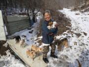 Jung Myoung Sook, 61, holds puppies she rescued at a shelter in Asan, South Korea. In the country, where dogs are considered a traditional delicacy and have only recently become popular as pets, Jung&#039;s love for her canine friends is viewed by some as odd.