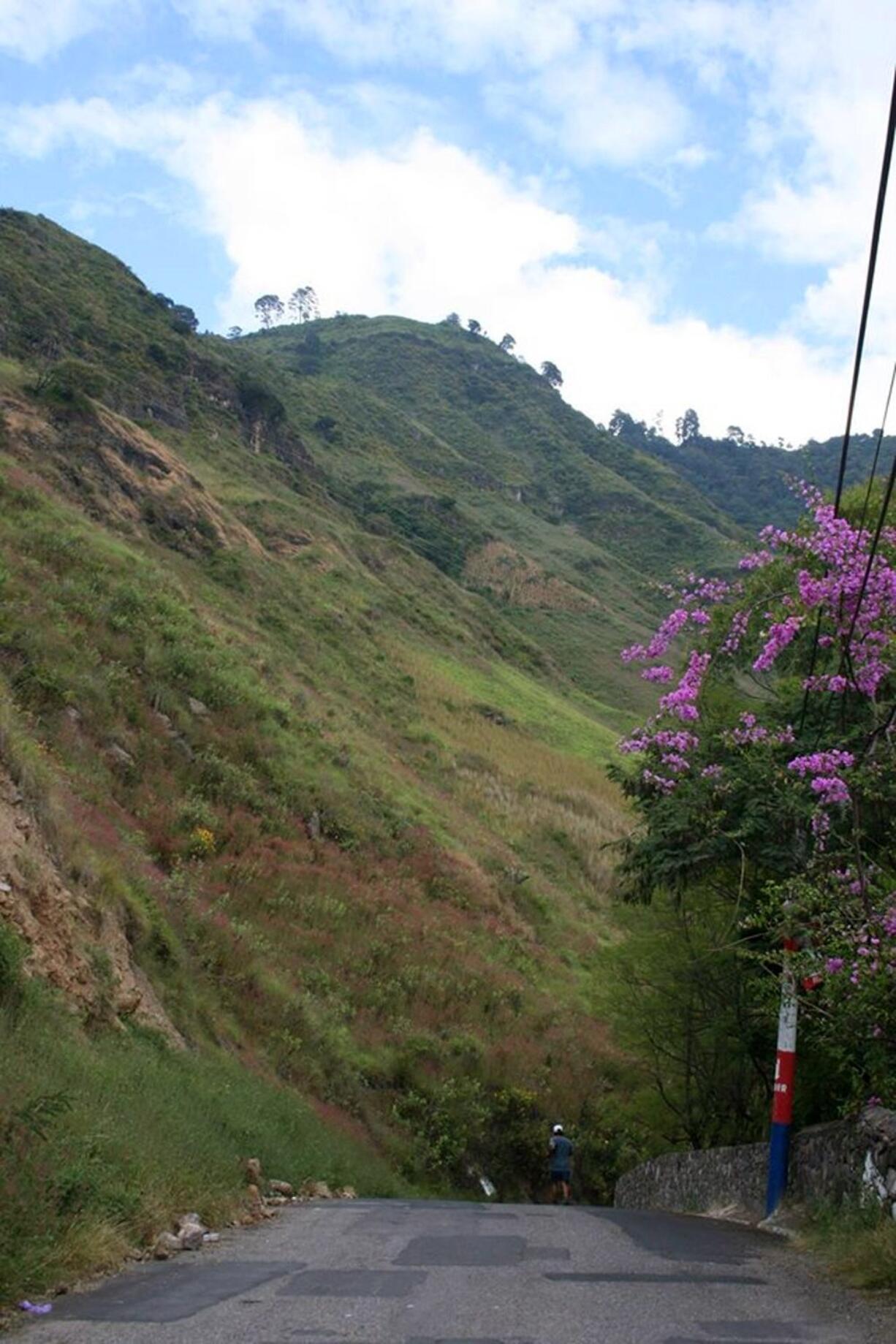 In this Nov. 2015 photo, a man runs along a road to Santa Catarina Palopo, a village along Guatemala&#039;s Lake Atitlan. The walk between Santa Catarina Palopo and Panajachel offers views of the lake, volcanoes and everyday village life.