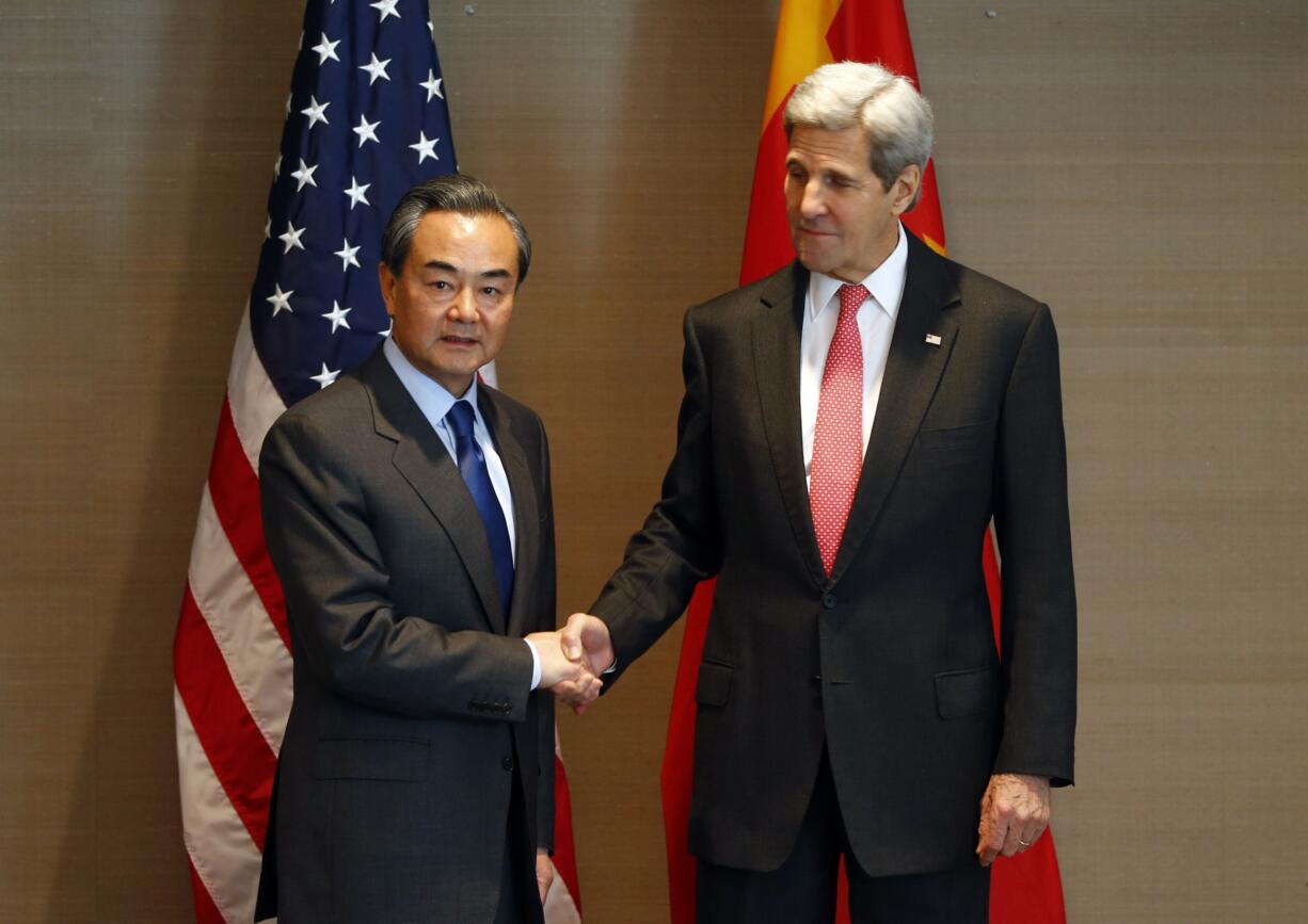 U.S. Secretary of State John Kerry, right, shakes hands with China&#039;s  Froreign, Minister Wang Yi,  during a meeting in Munich, Germany, before the Munich Security Conference. The top diplomats of the U.S. and China meet Feb. 23, in Washington at a fraught time in relations between the two world powers.