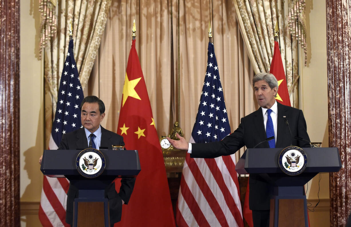 Secretary of State John Kerry, right, speaks during a media availability with Chinese Foreign Minister Wang Yi, left, at the State Department in Washington, Tuesday, Feb.