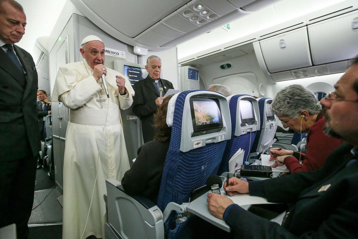 Pope Francis meets journalists aboard the plane during the flight from Ciudad Juarez, Mexico to Rome, Italy, on Thur sday.