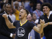 Golden State Warriors guard Stephen Curry (30) celebrates after hitting the game-winning shot in overtime of an NBA basketball game against the Oklahoma City Thunder in Oklahoma City, Saturday, Feb. 27, 2016. Golden State won 121-118.