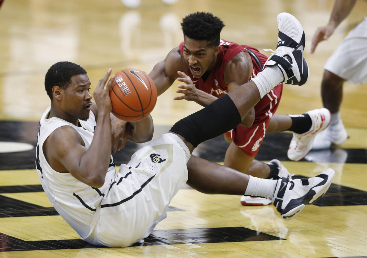 Colorado forward Tory Miller, left, passes the ball after picking it up in a scramble with Washington State guard Ny Redding early in the second half of an NCAA college basketball game Thursday, Feb. 11, 2016, in Boulder, Colo.